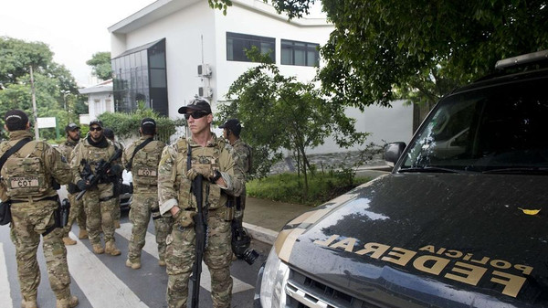 Federal police officers are deployed at the Lula Institute headquarters in Sao Paulo, Brazil on March 04, 2016. Police searched the home of Brazil's powerful ex-president Luiz Inacio Lula da Silva and detained him for questioning Friday in a probe into a huge corruption scheme. Agents searched his house in Sao Paulo, the offices of the Lula Institute, and houses of family members, Jose Chrispiniano, a spokesman for Lula and his institute, told AFP.AFP PHOTO / NELSON ALMEIDA